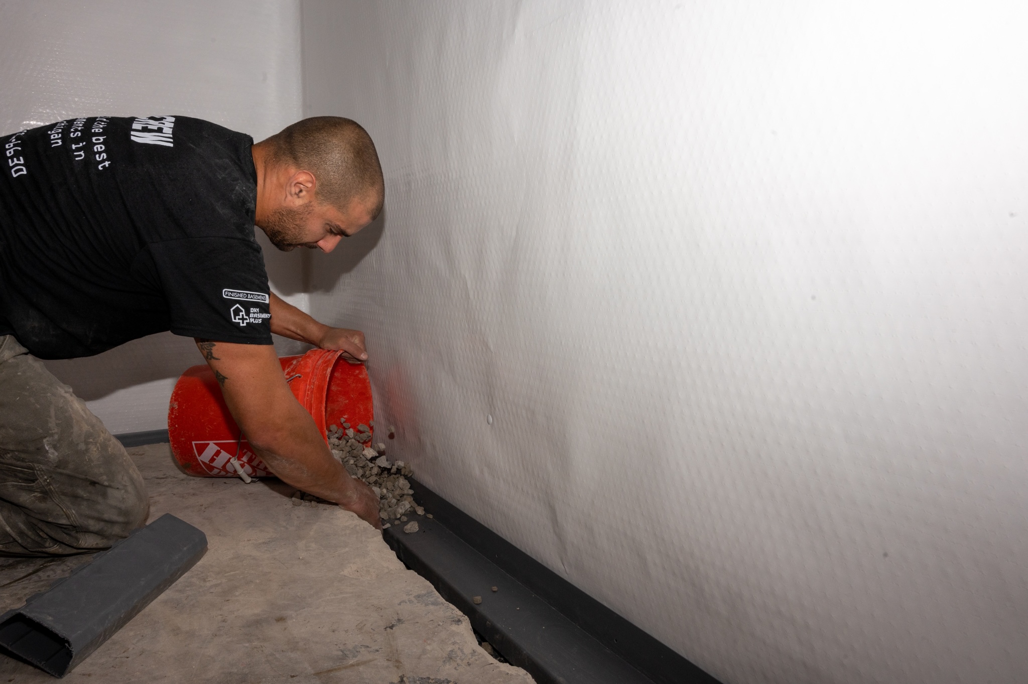 Crew member pouring rock during a WaterGuard installation 