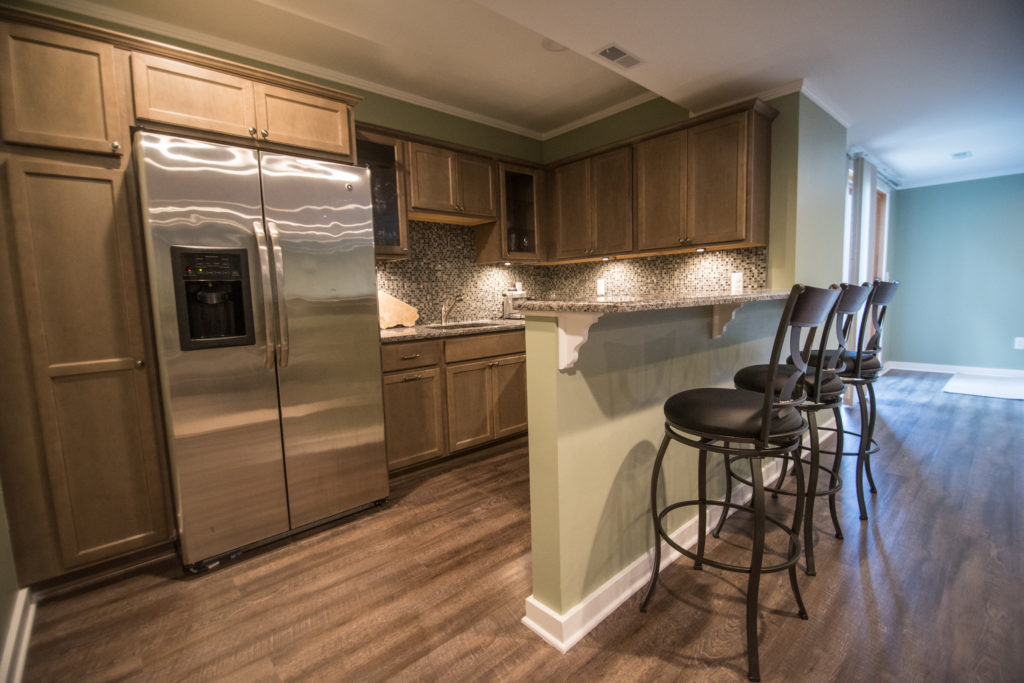 kitchen in finished basement with vinyl plank flooring and bar seating