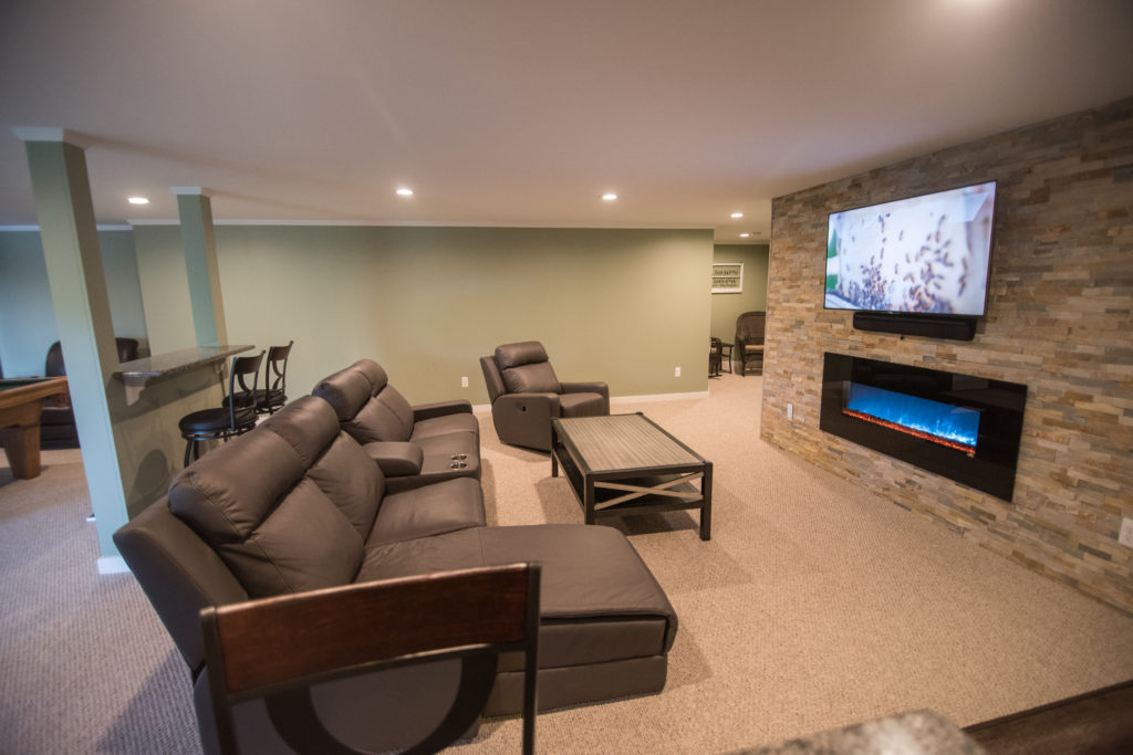 large open living room space with electric fireplace and recliners