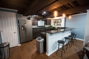 bar area in basement with painted ceiling and dark cabinets
