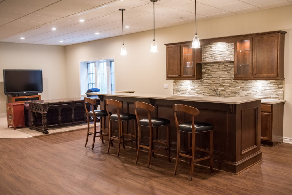 basement with high ceilings and custom bar area with granite countertops