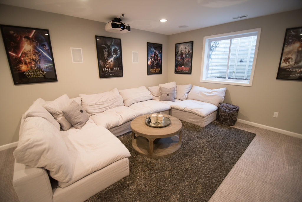 large cozy sectional in finished basement with carpeting and bright design