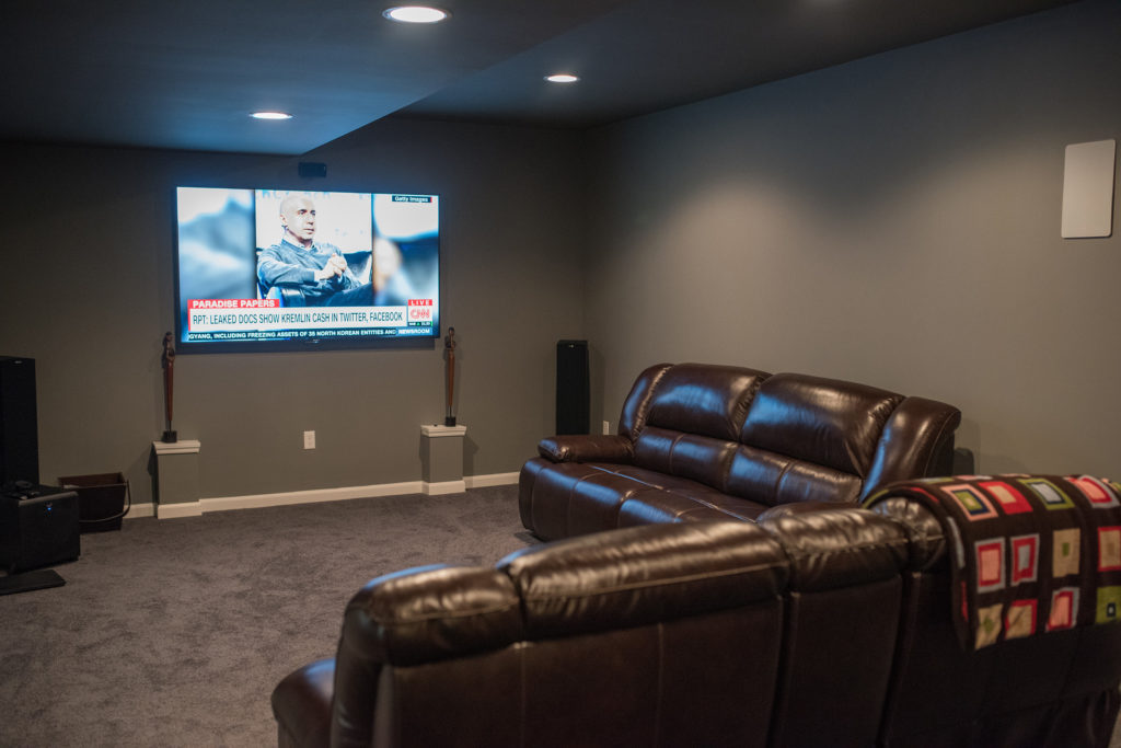 basement media room with large tv for movies and sports