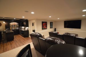 basement with theater and bar area carpeting and vinyl plank flooring