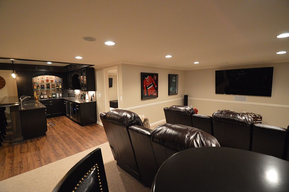 basement with theater and bar area carpeting and vinyl plank flooring