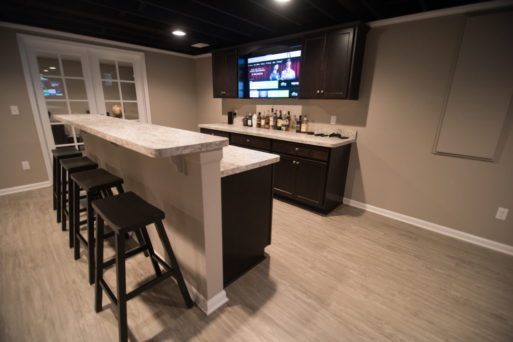 finished basement with dark cabinetry and laminate countertops
