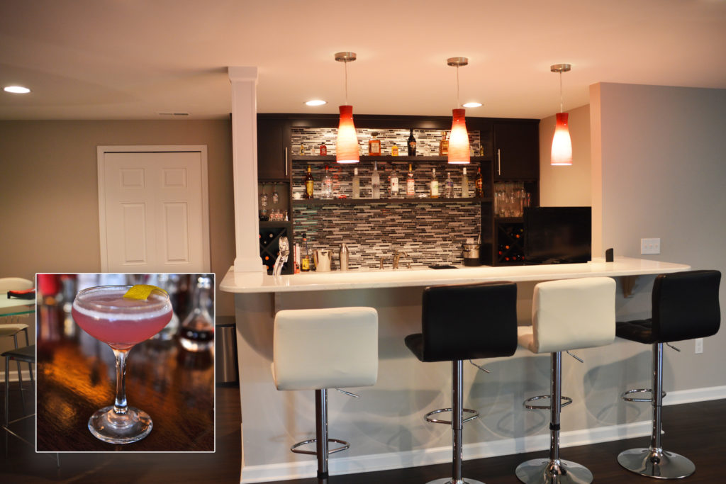 finished basement bar with dark cabinetry and pendant lights
