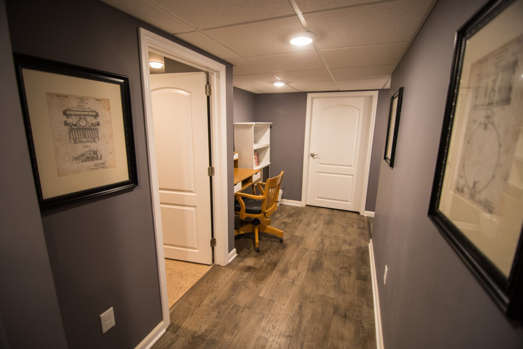 vinyl plank flooring in finished basement leading to small office