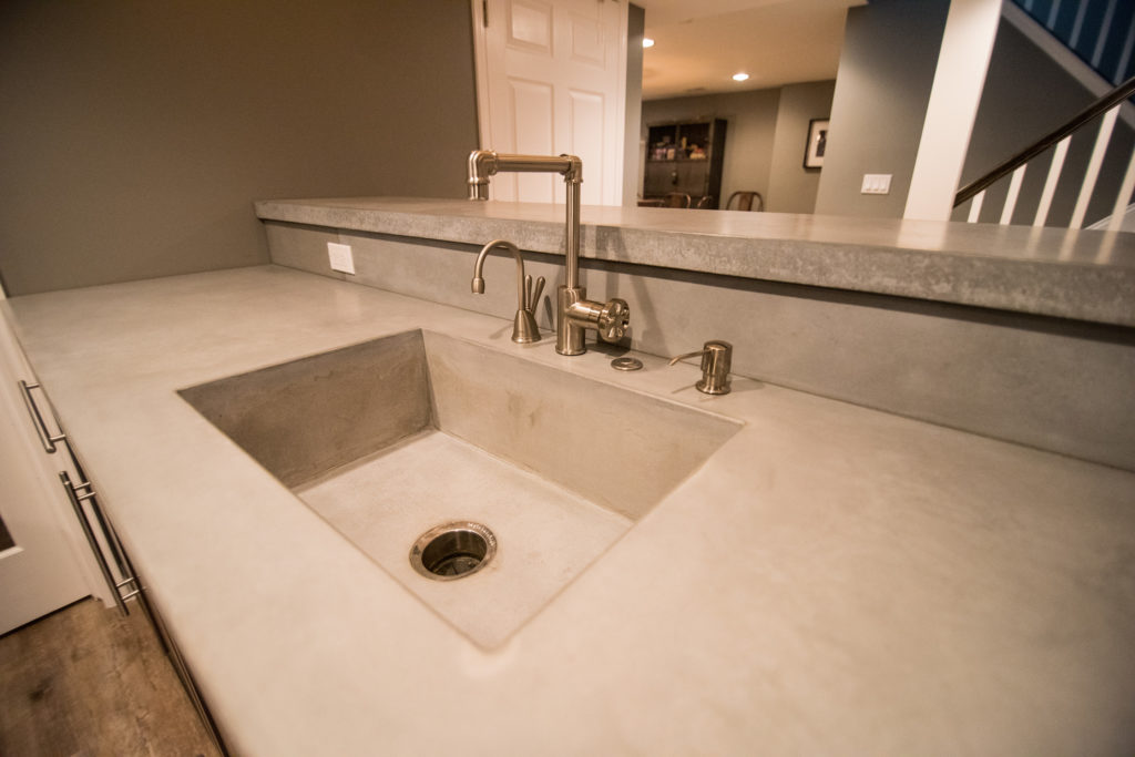 concrete countertops with built in sink and rustic faucets