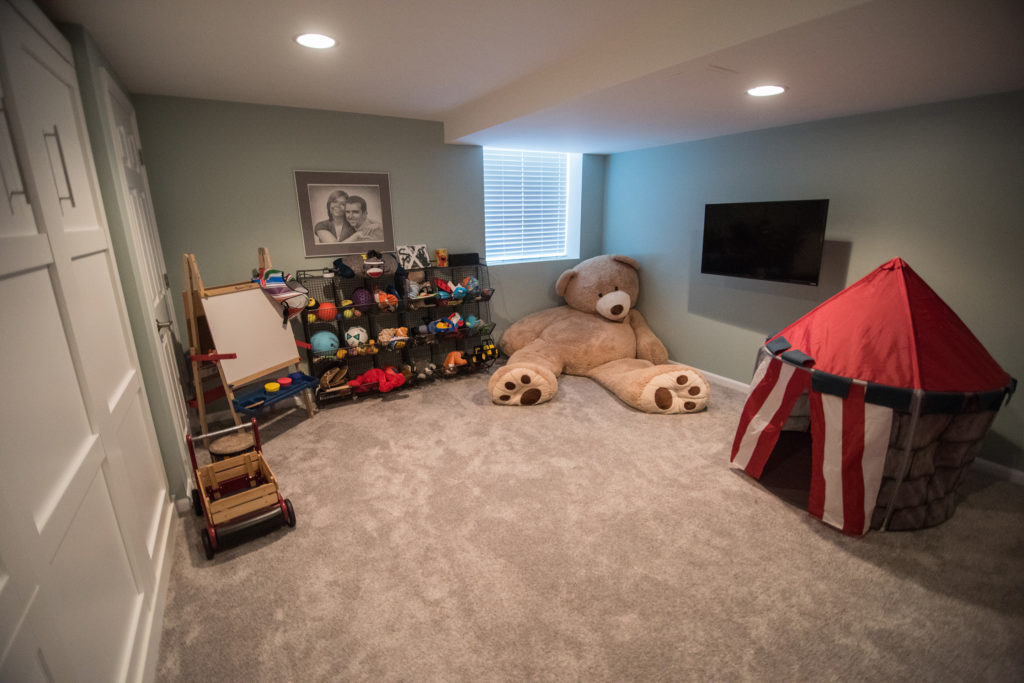 basement playroom with carpet and storage for toys