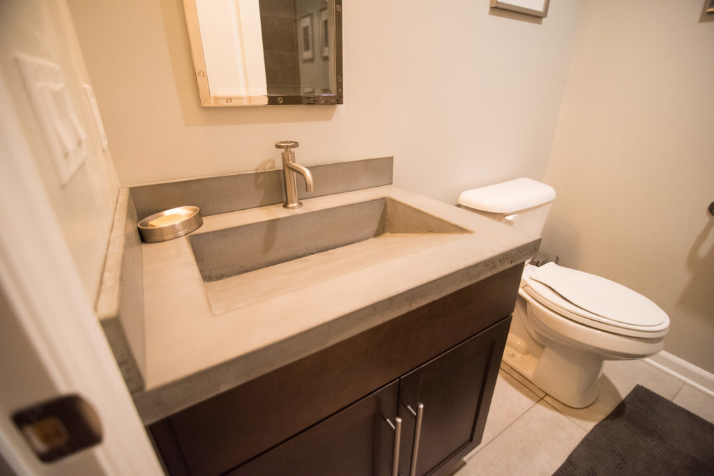basement bathroom with vinyl tile flooring and concrete countertops