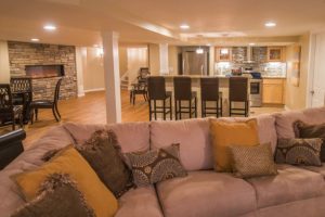 bright and open concept basement with sectional and kitchen