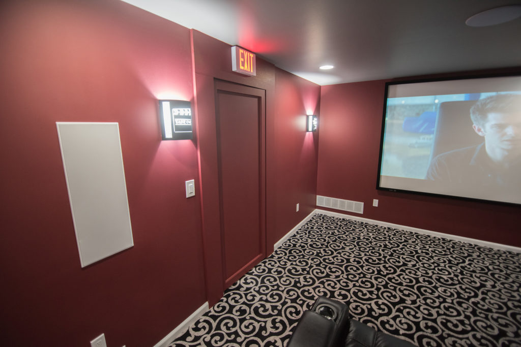 exit sign and sconce lighting in basement movie theater northville