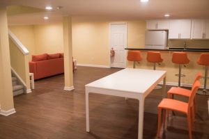 open concept living and dining space in basement with vinyl plank flooring
