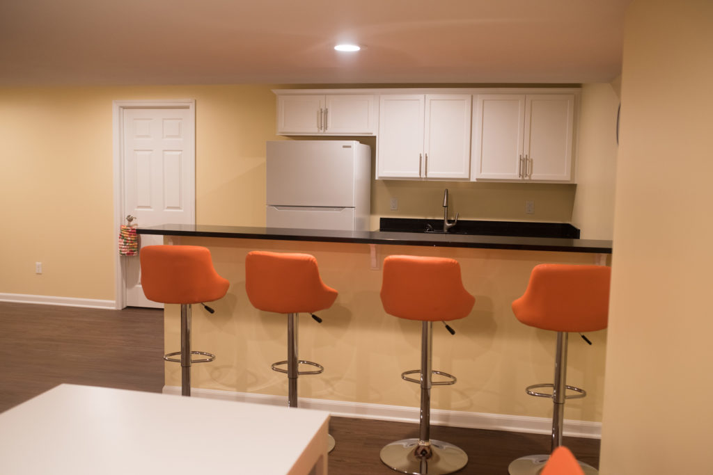 basement bar with seating and granite countertops