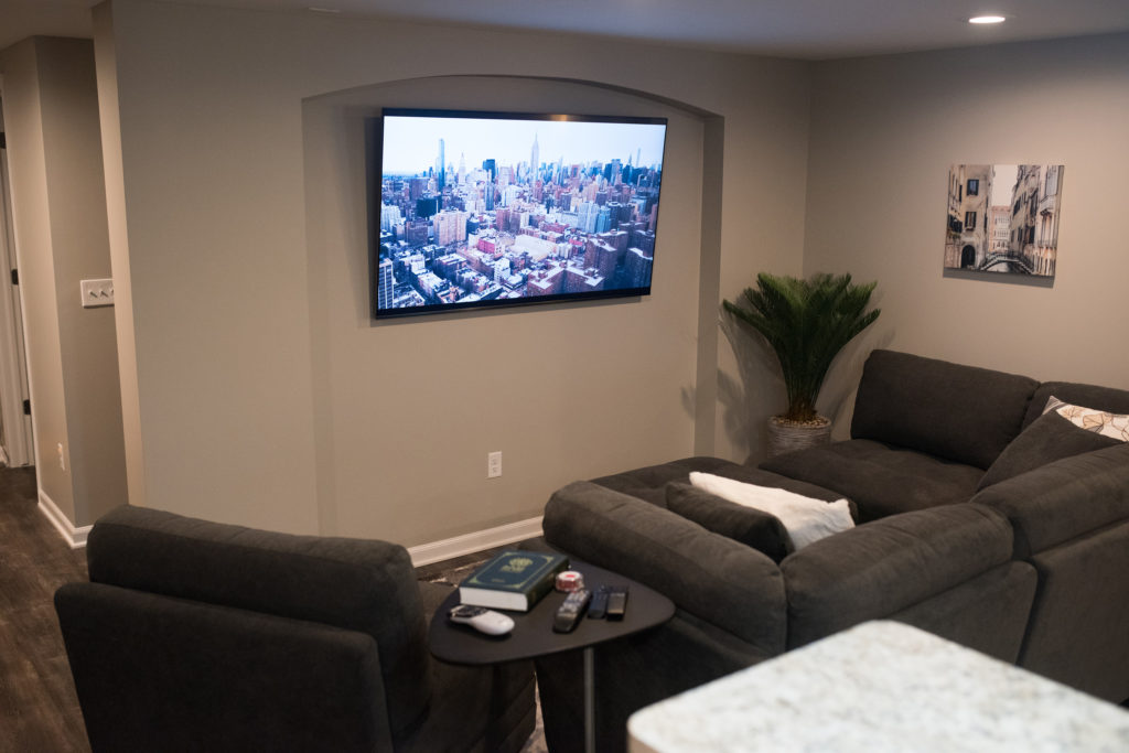 living room area in basement with tv archway