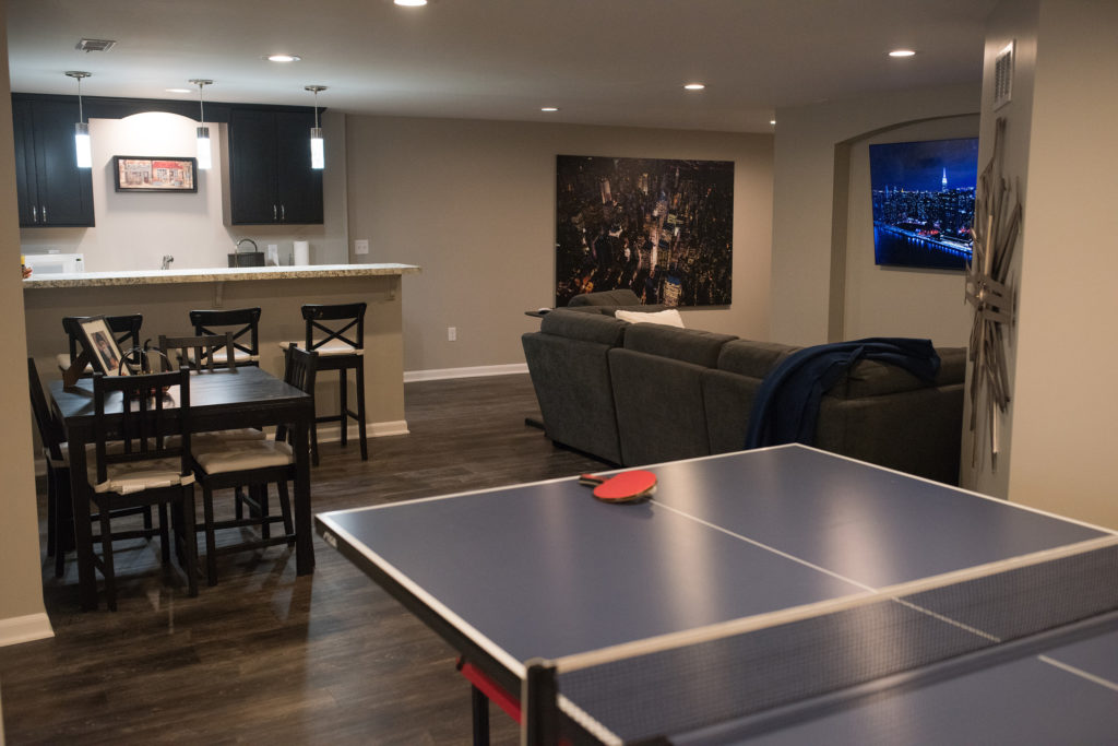 ping pong table in finished basement novi with dark vinyl plank flooring