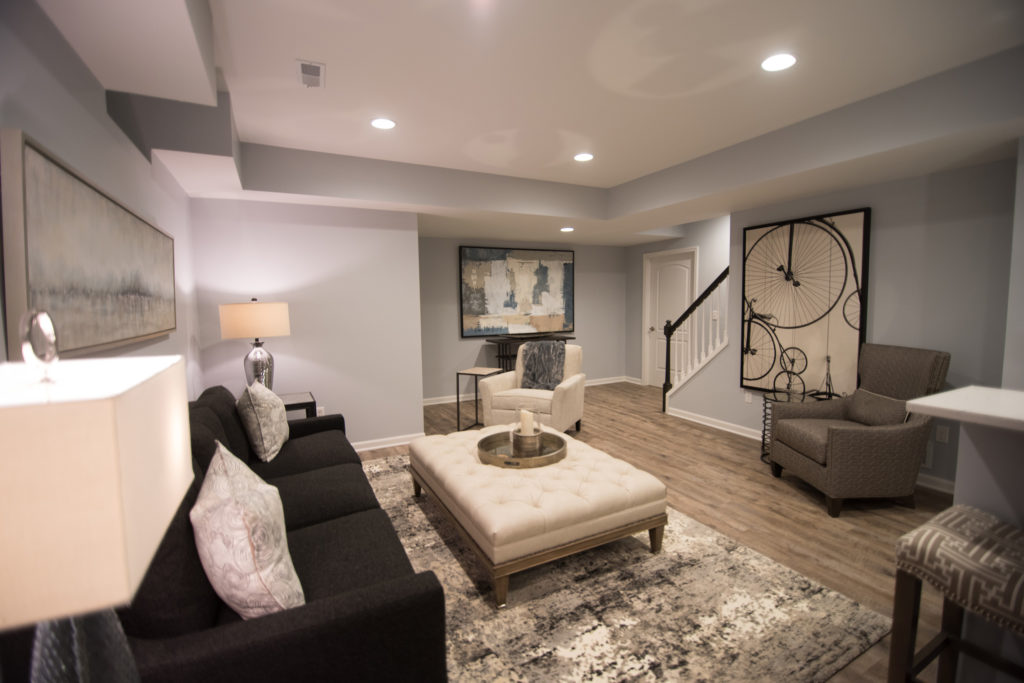 large open finished basement with vinyl plank flooring and modern design