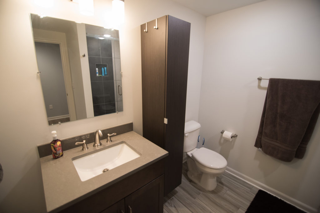 finished basement bathroom with shower and vinyl tile