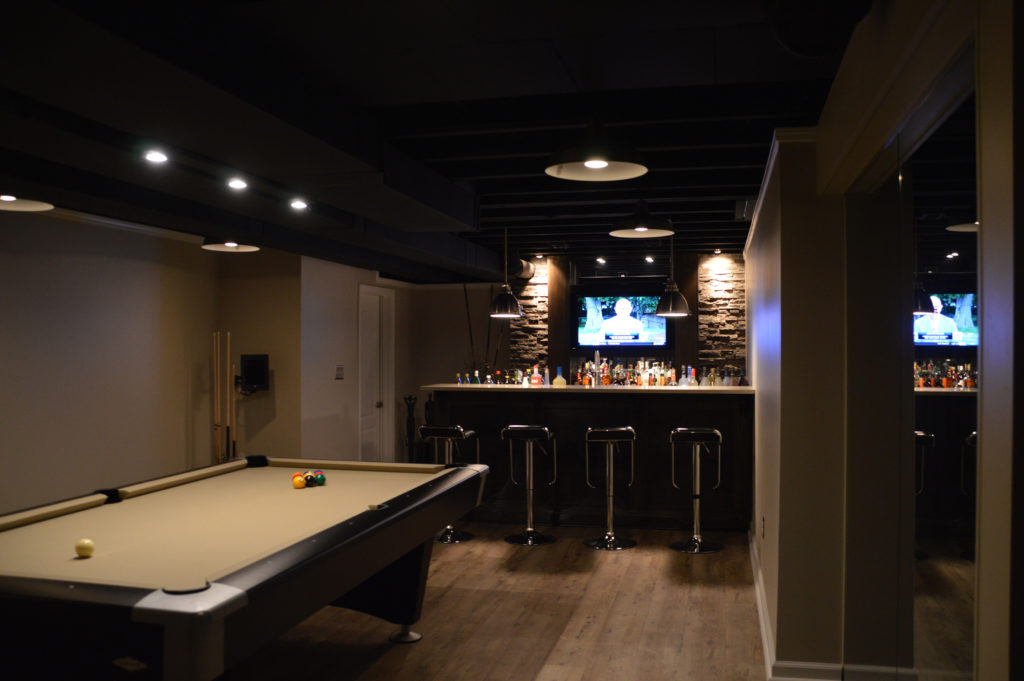 basement bar with dark features and modern design such as stone veneer