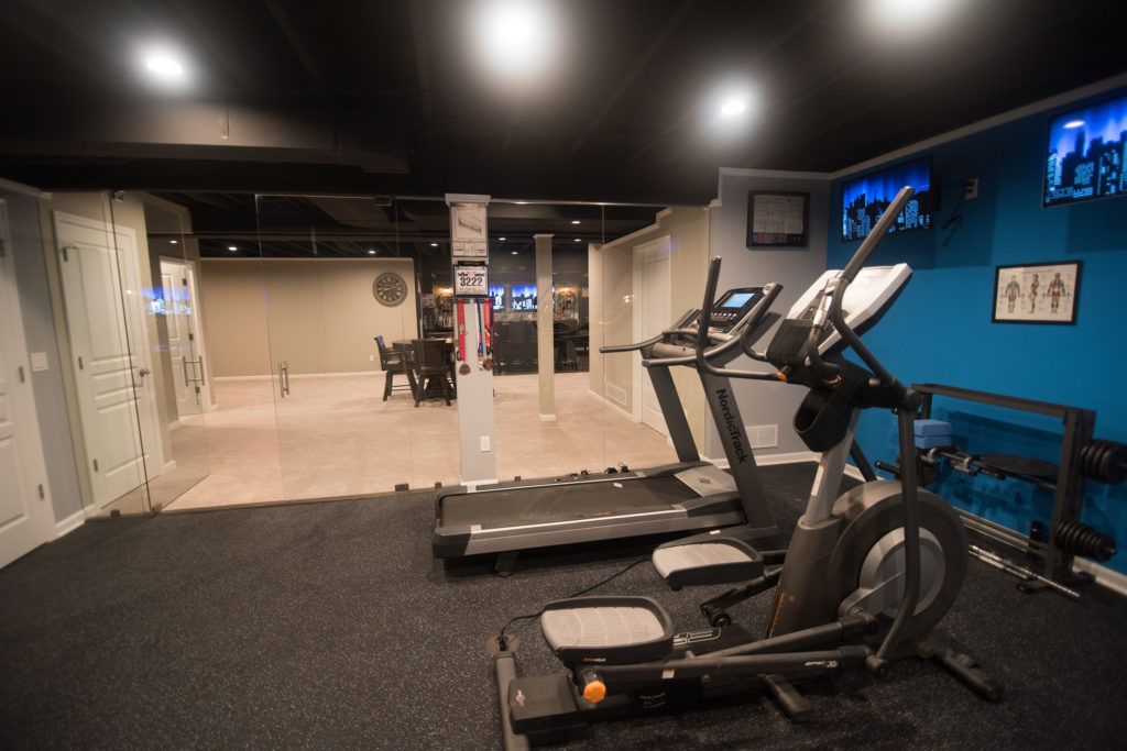 basement fitness room with rubber flooring and painted ceiling