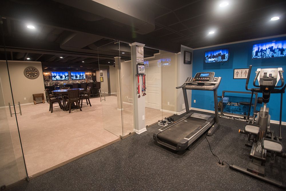 basement fitness room with rubber flooring and blue walls