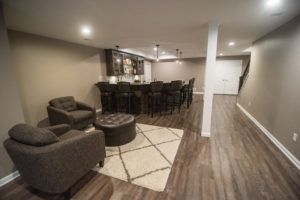 basement bar area with seating and vinyl plank flooring