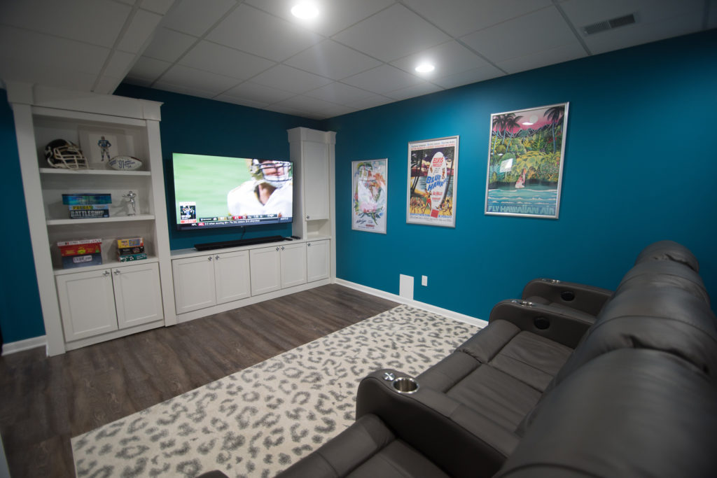 bright blue finished basement living room with custom book shelf