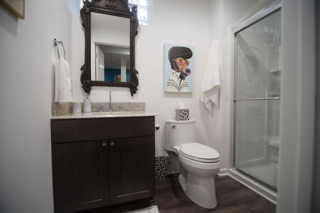 basement bathroom with dark vanity with granite top