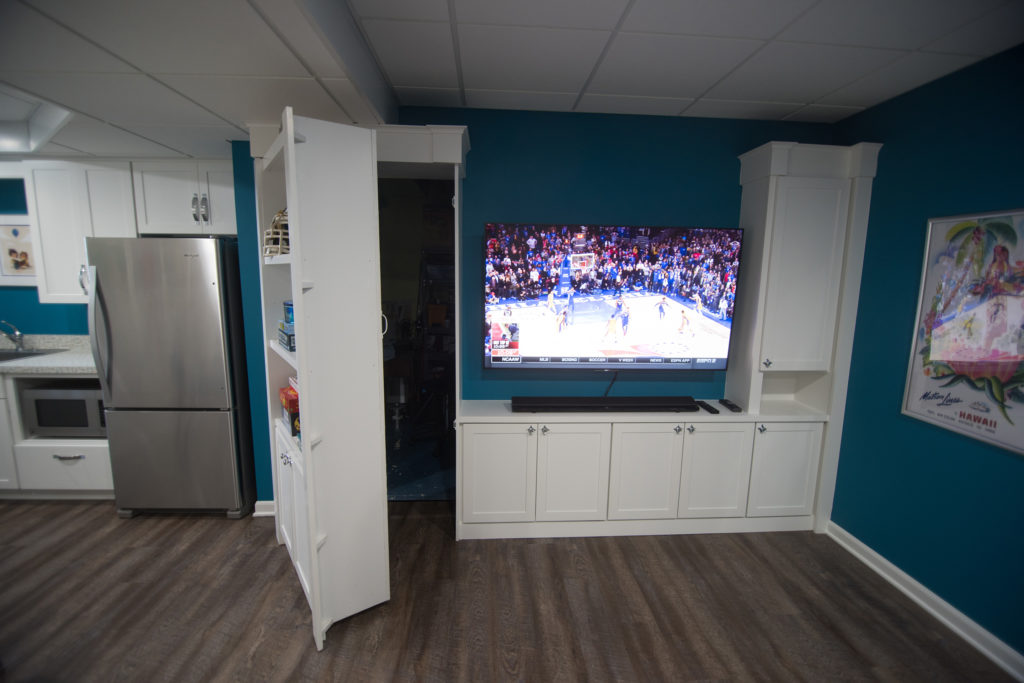 secret door in bookshelf leading to unfinished portion of basement built into bookshelf