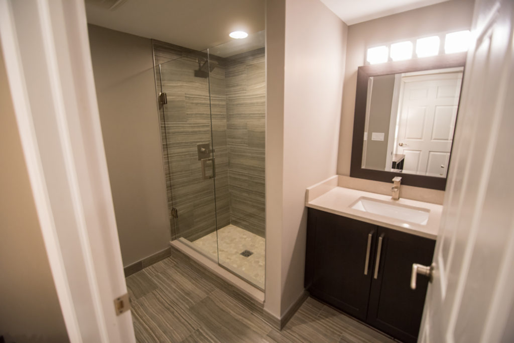 basement bathroom with tile flooring and matching shower