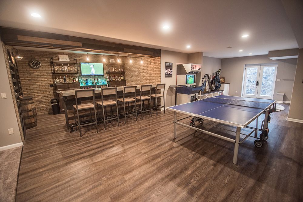 vinyl plank flooring with a ping pong table and bright industrial custom bar