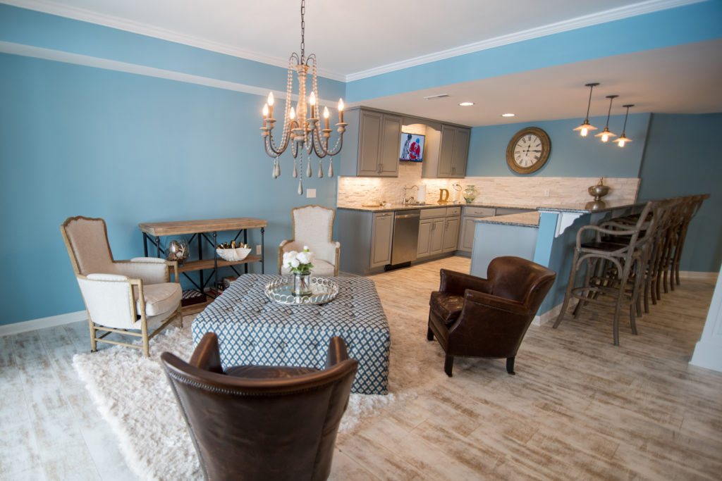 walkout basement with a seating area adjacent to the bar with large chairs and ottoman