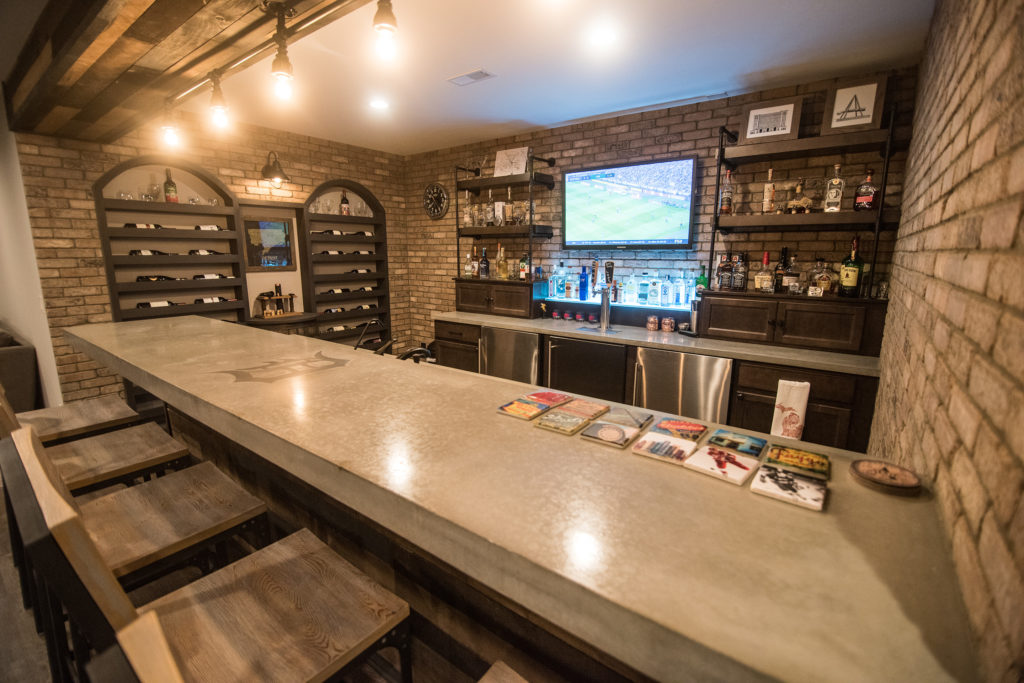 concrete countertops with an industrial style bar and brick walls