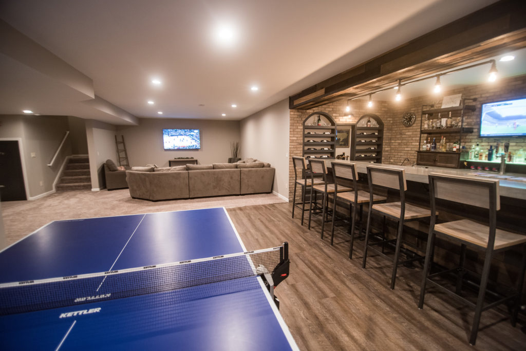 large finished basement with vinyl plank flooring and industrial bar