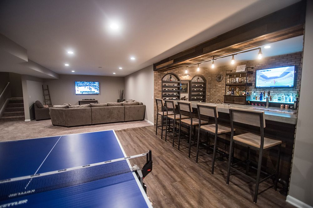 Industrial basement design with bar and living room with vinyl plank in South Lyon, Michigan