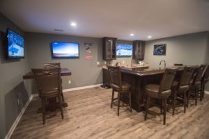 plenty of seating available in this basement bar with vinyl plank flooring