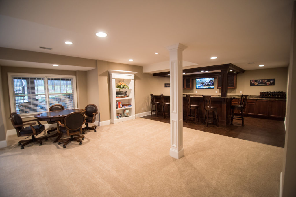 spacious basement living room with carpet and post wrap