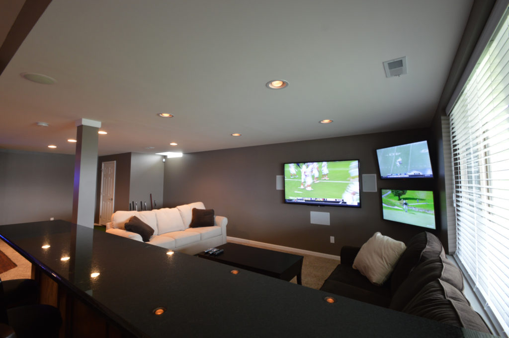 basement living room with granite seating area behind couch