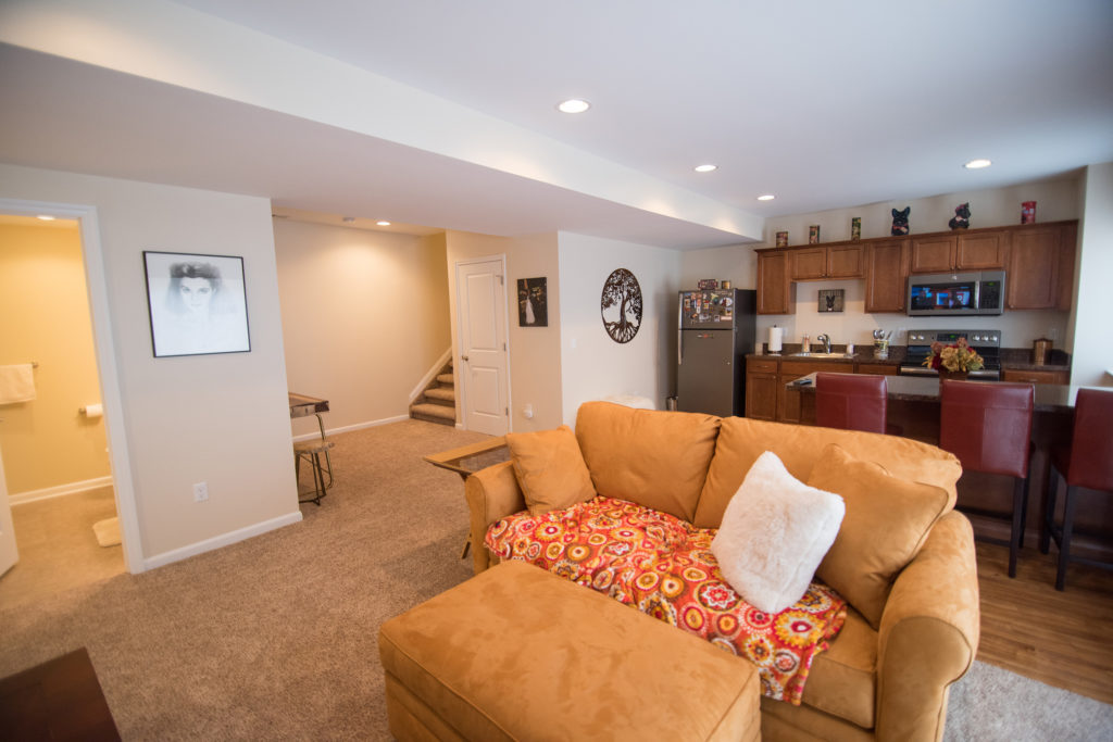 open concept basement with carpeting and kitchen