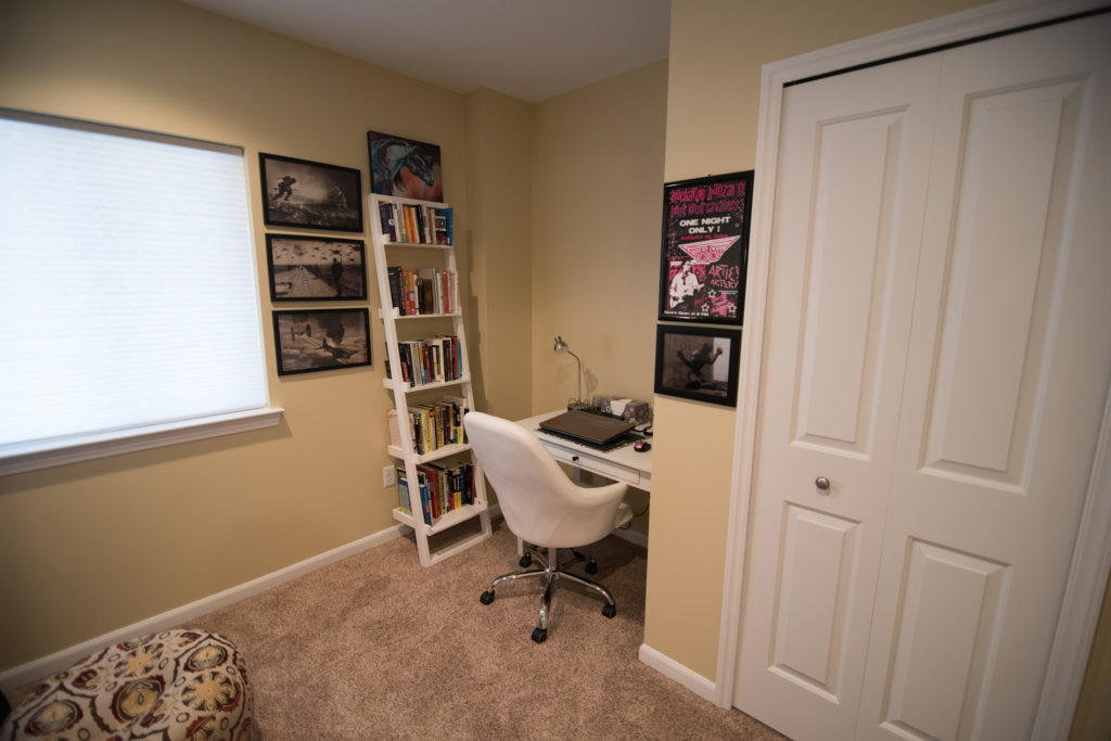 small home office in basement with desk and carpet