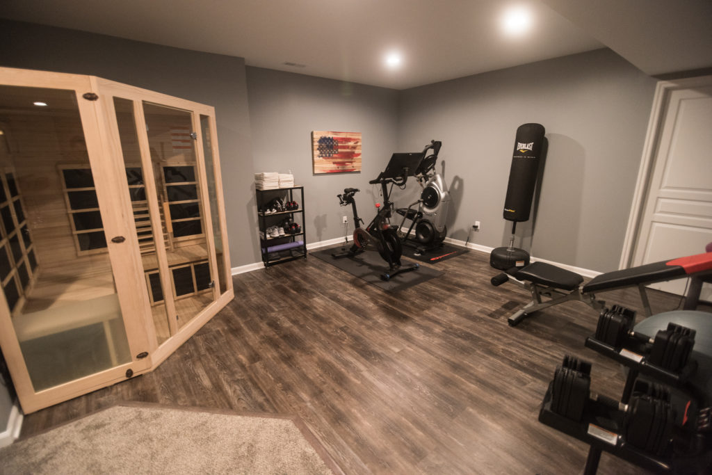 fitness space in basement with vinyl plank flooring and sauna
