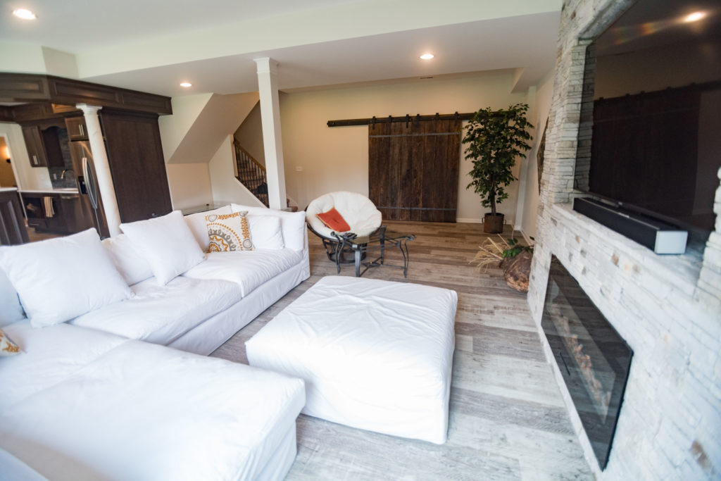 stone fireplace wall and electric fireplace with large sofa