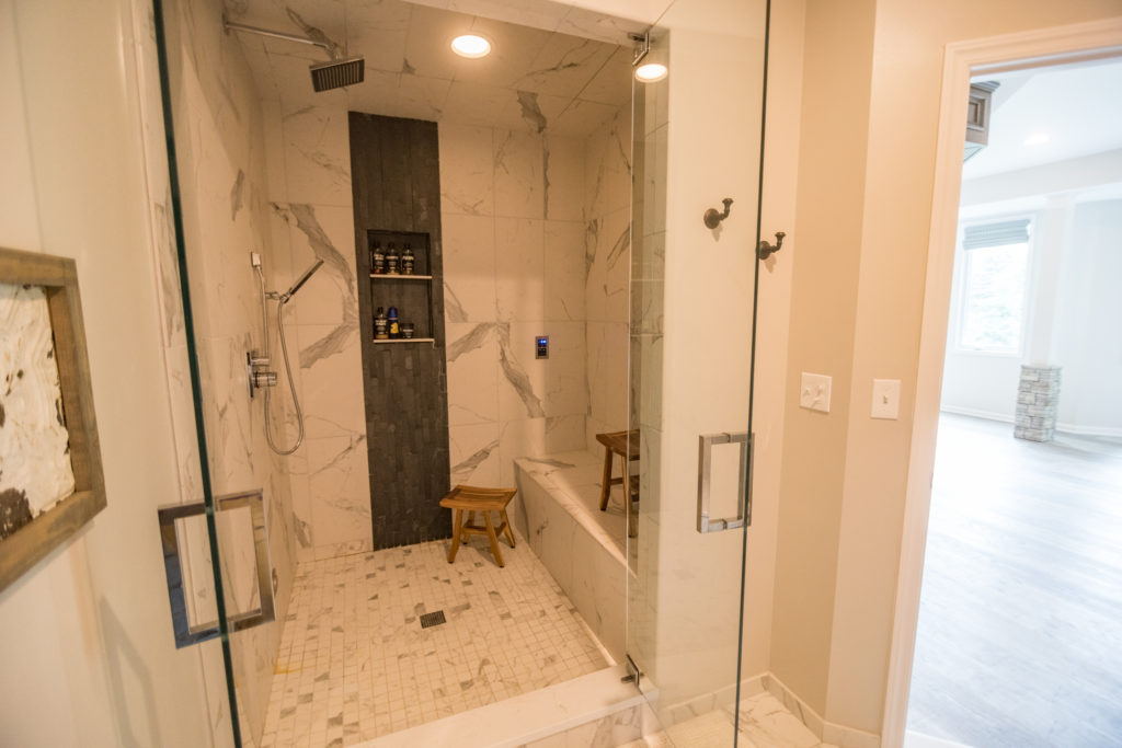 tile steam shower in basement with dark tile accent
