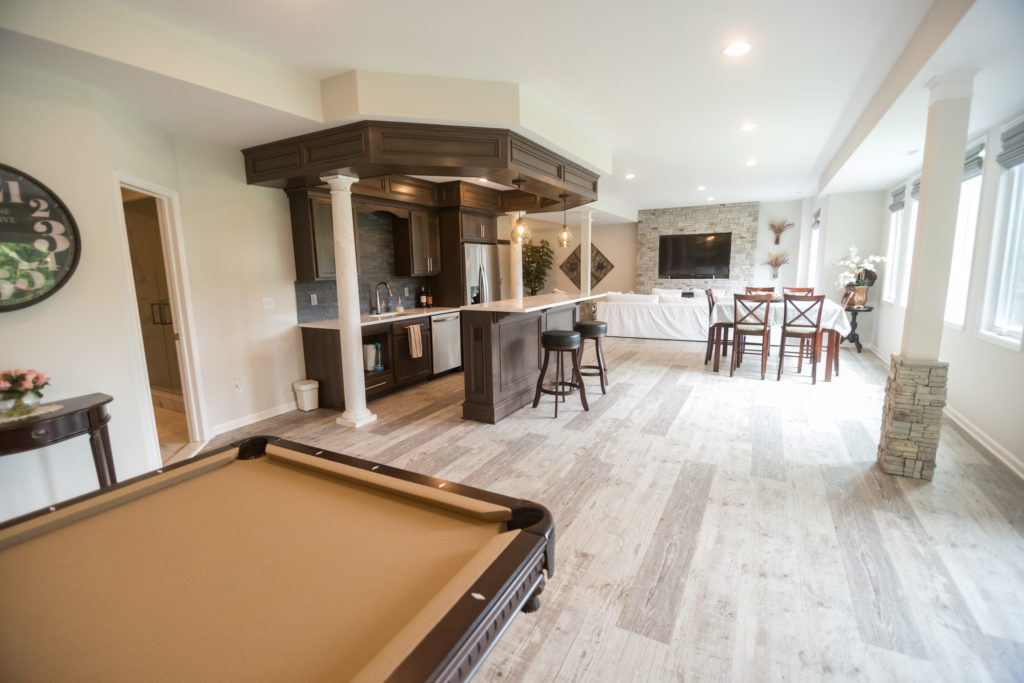 light vinyl plank flooring in walkout basement with bar