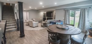 finished walkout basement with light brown vinyl plank flooring and modern design