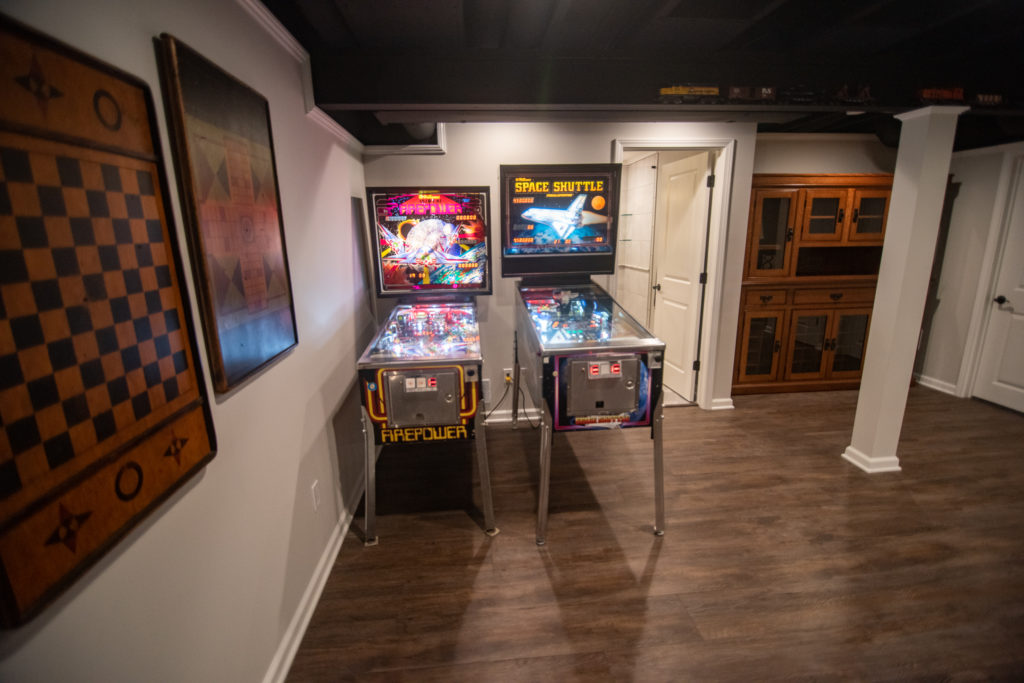 pinball machines in basement with hickory vinyl plank flooring