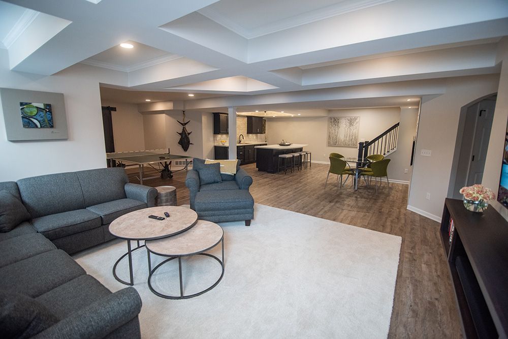 bright open concept living room design finished basement with vinyl plank flooring