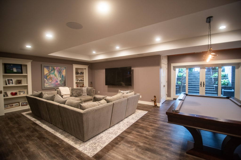 tv area in basement with wall mounted tv and sectional