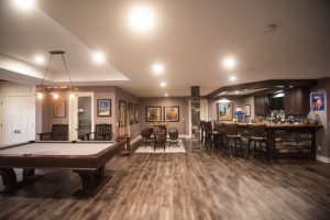 finished basement with open space vinyl plank flooring and brown tones